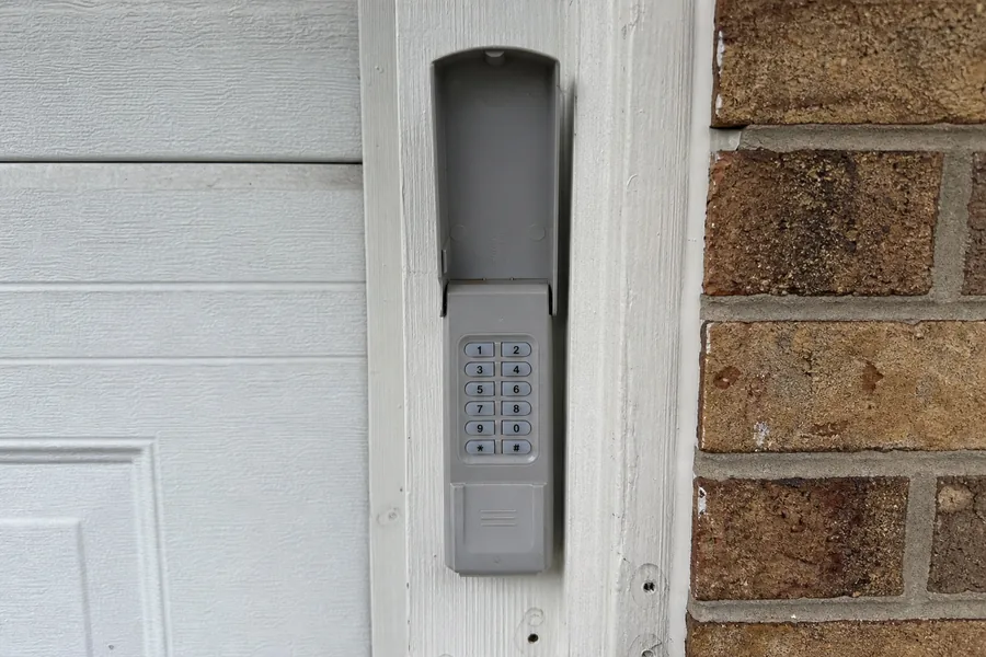 Hinges and roller along a panel seam of a garage door in Irving, TX