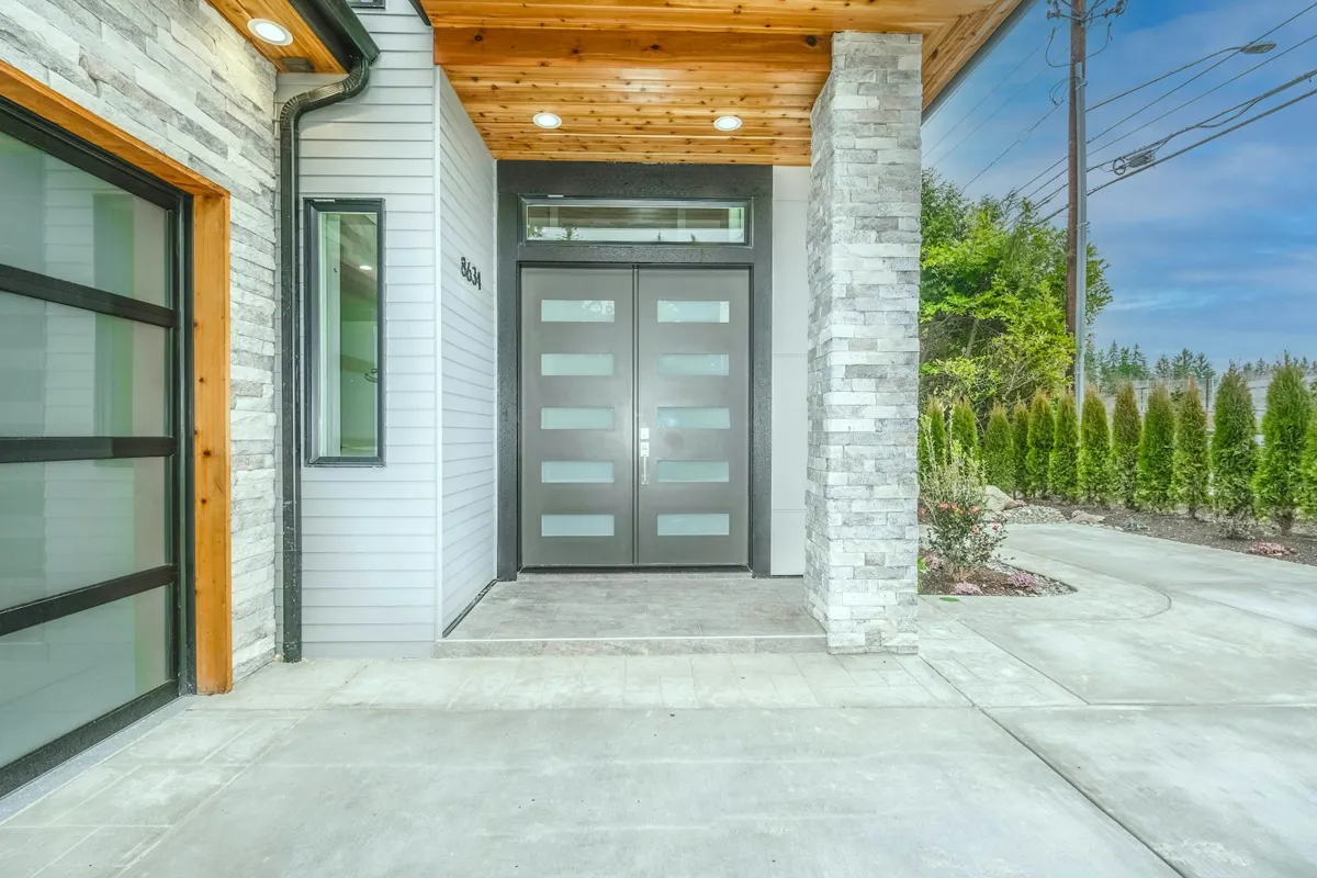 Modern entry beside a full-view glass garage door