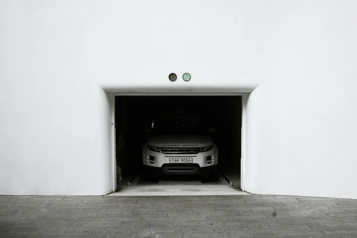 Car parked inside a white garage opening